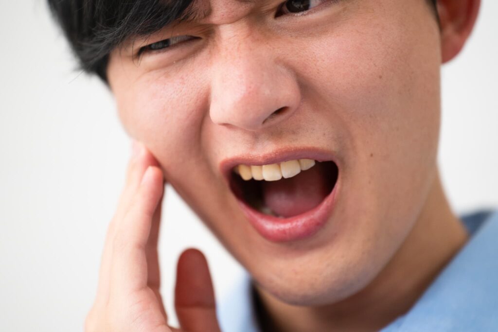 顎関節症で顎に痛みを感じる男性