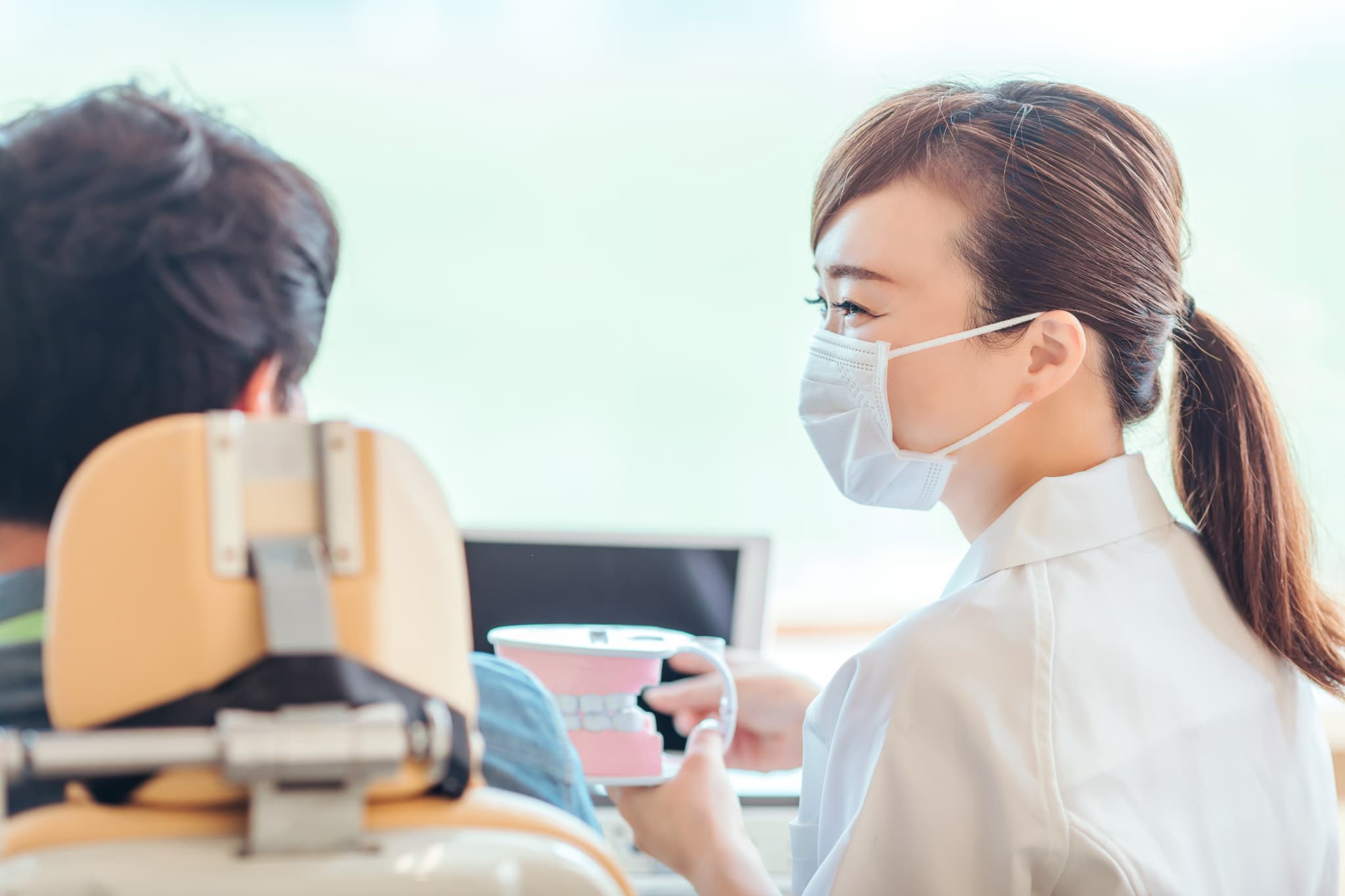 歯医者の定期検診について説明する歯科衛生士