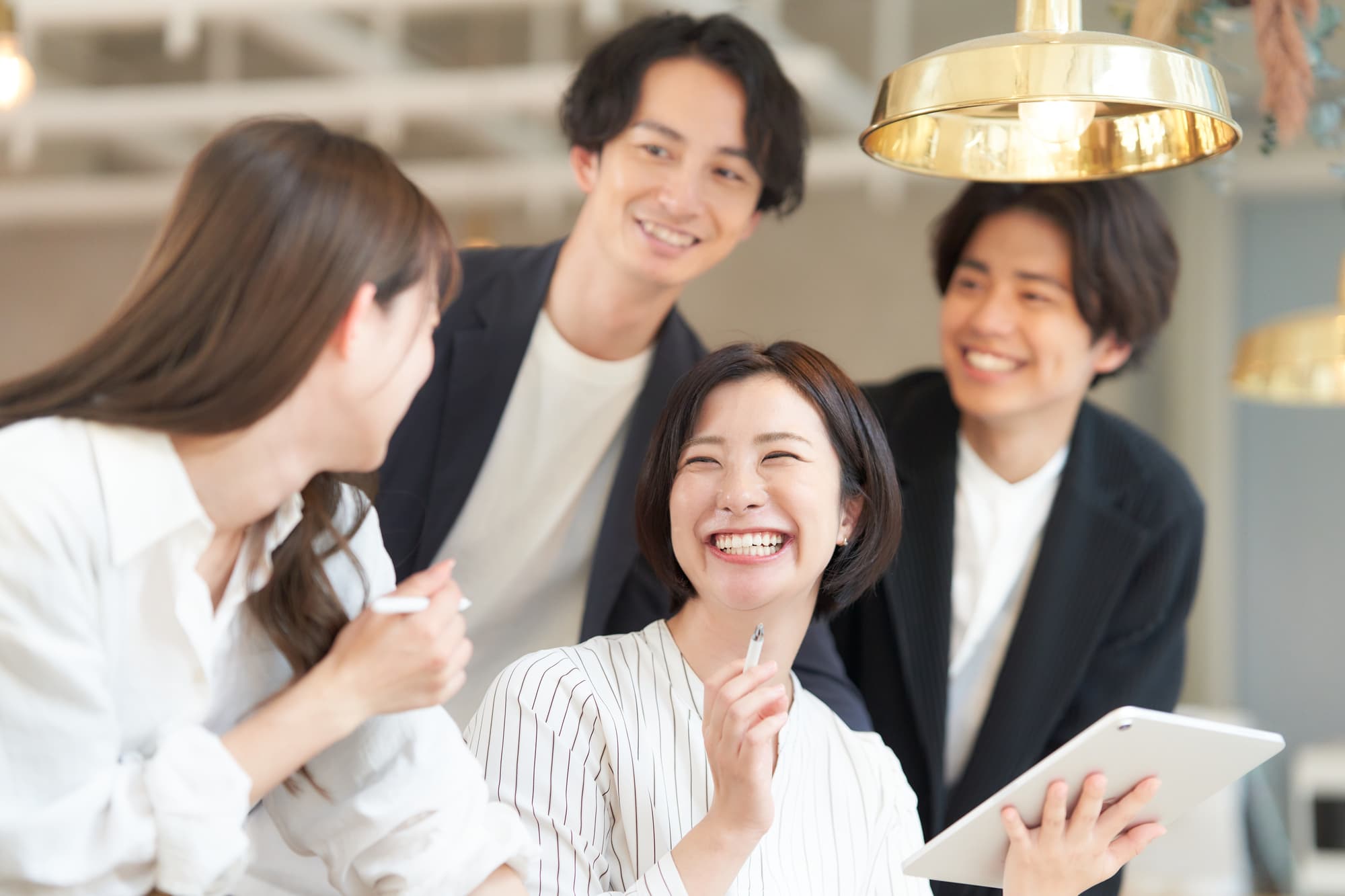 職場の仲間たちと楽しそうに会話をする女性