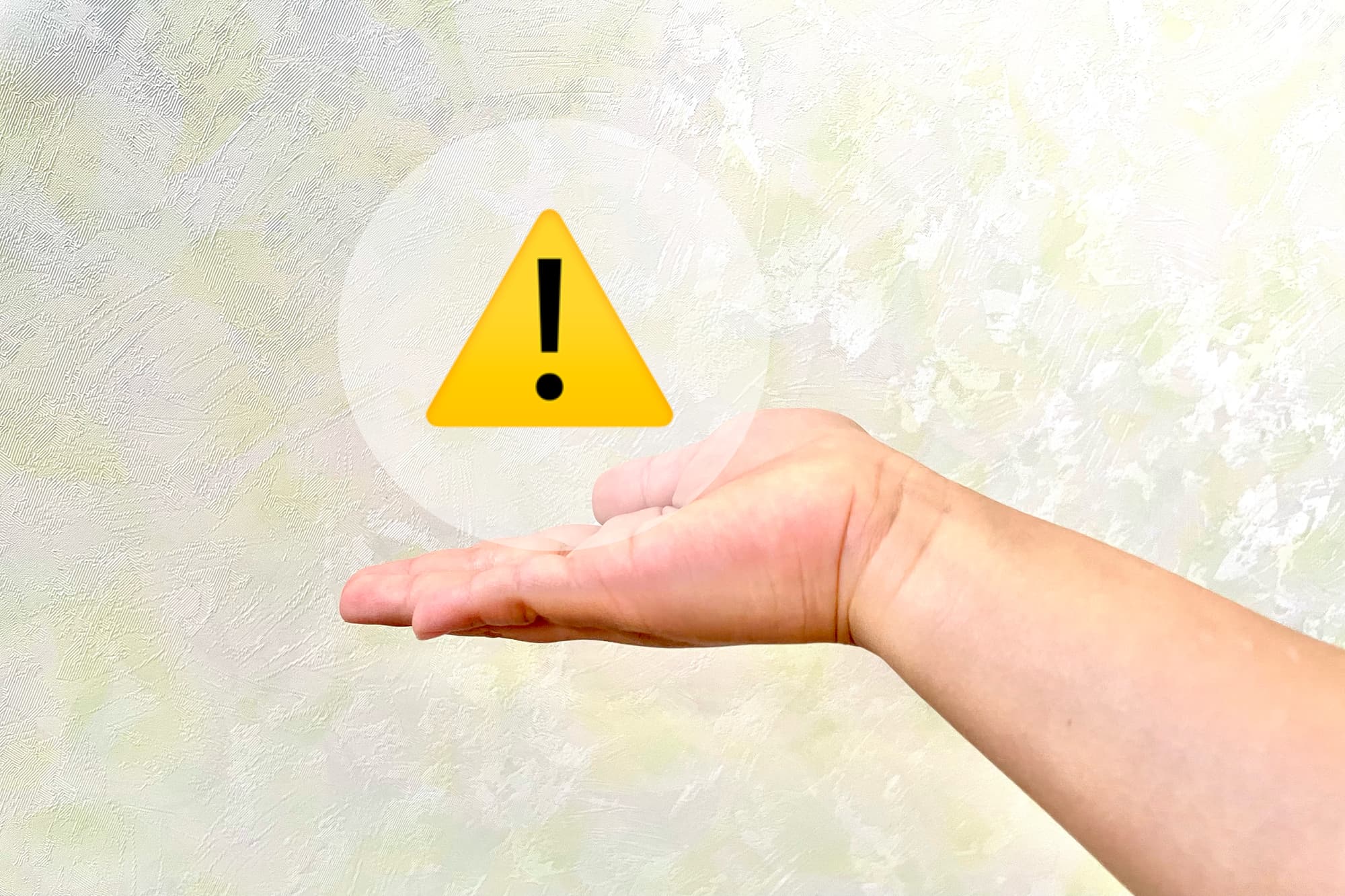 赤ちゃんの手のひらに乗せた注意マーク