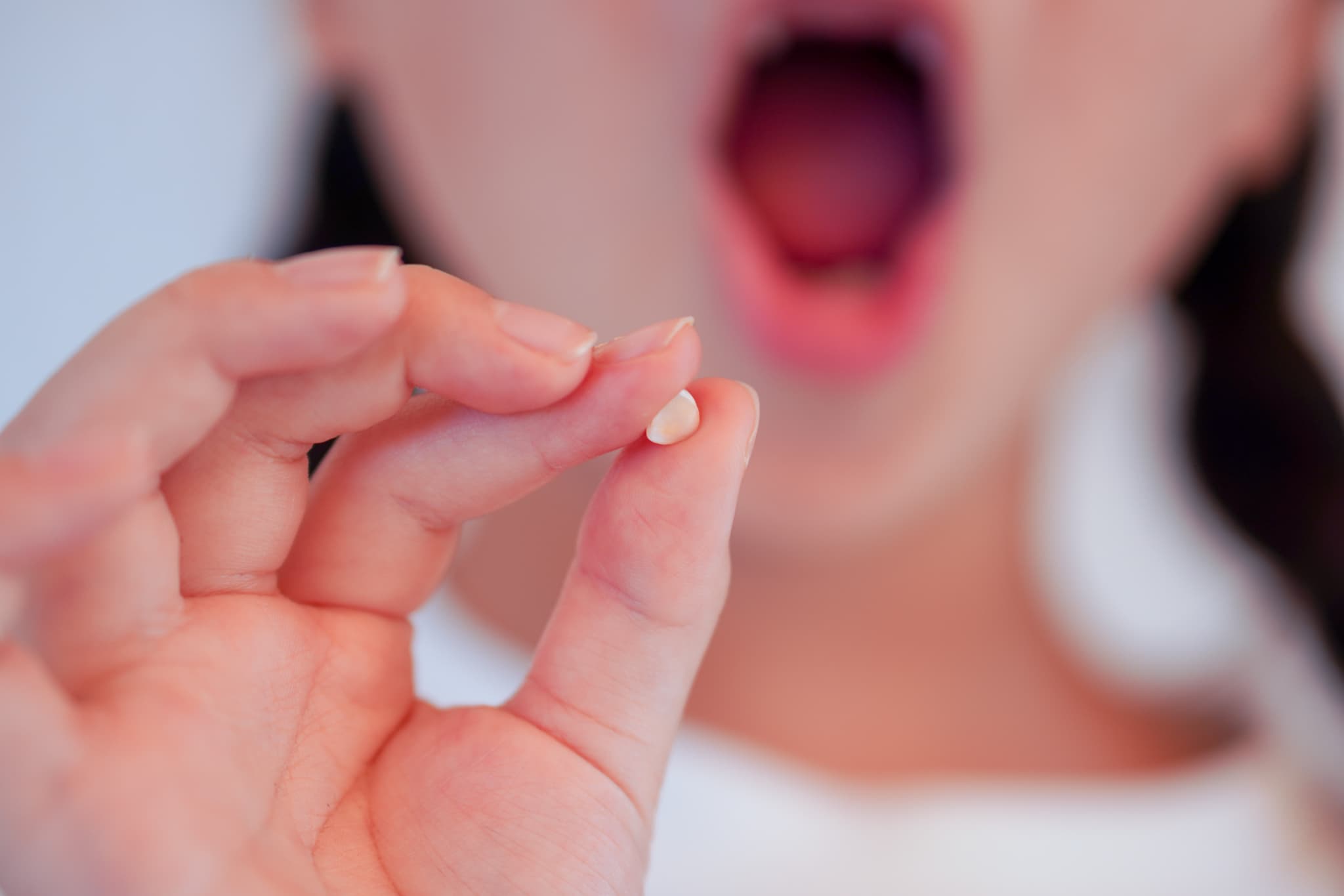 抜けた乳歯を見せる女の子