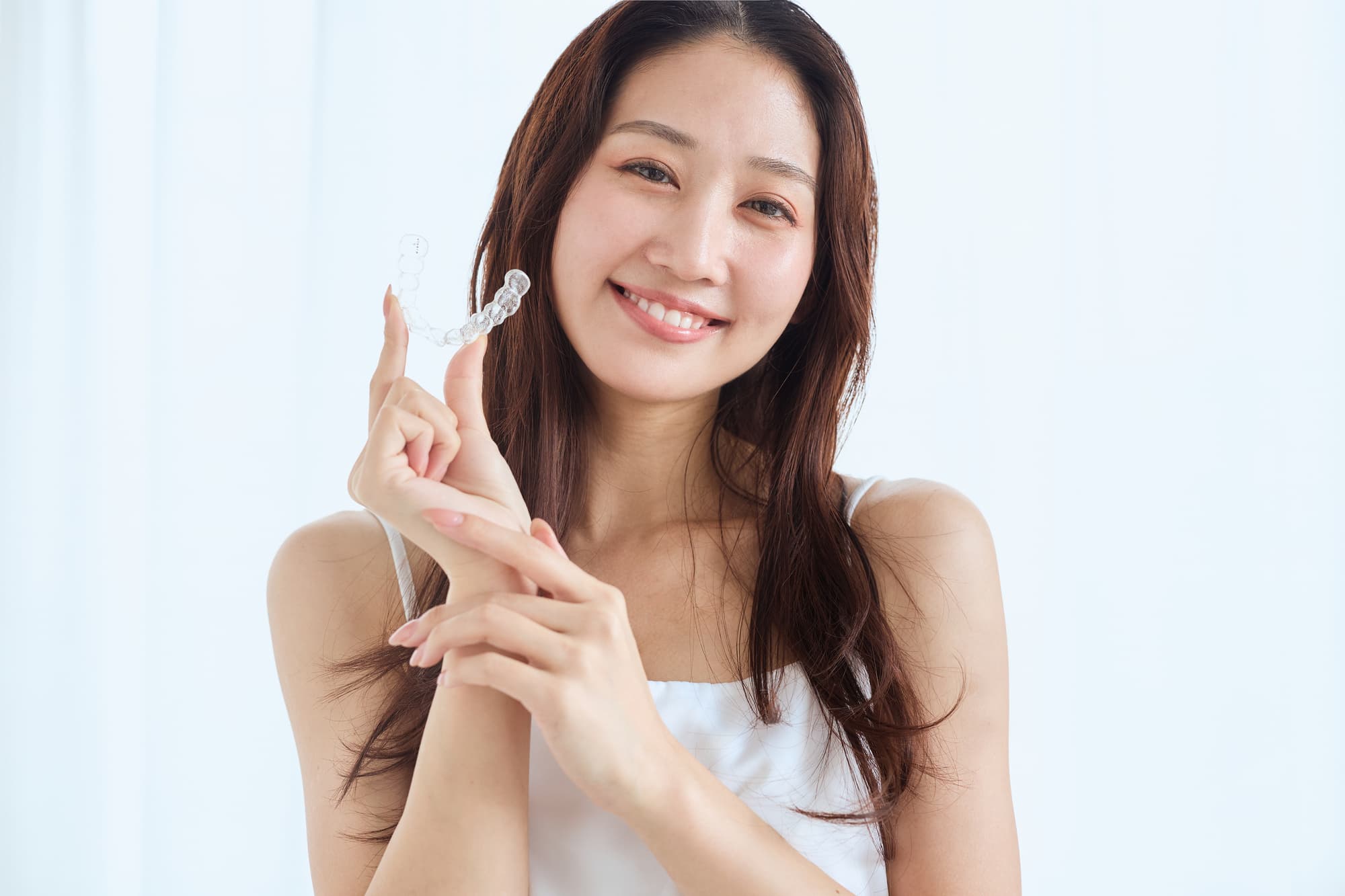 笑顔を見せるマウスピース矯正中の女性