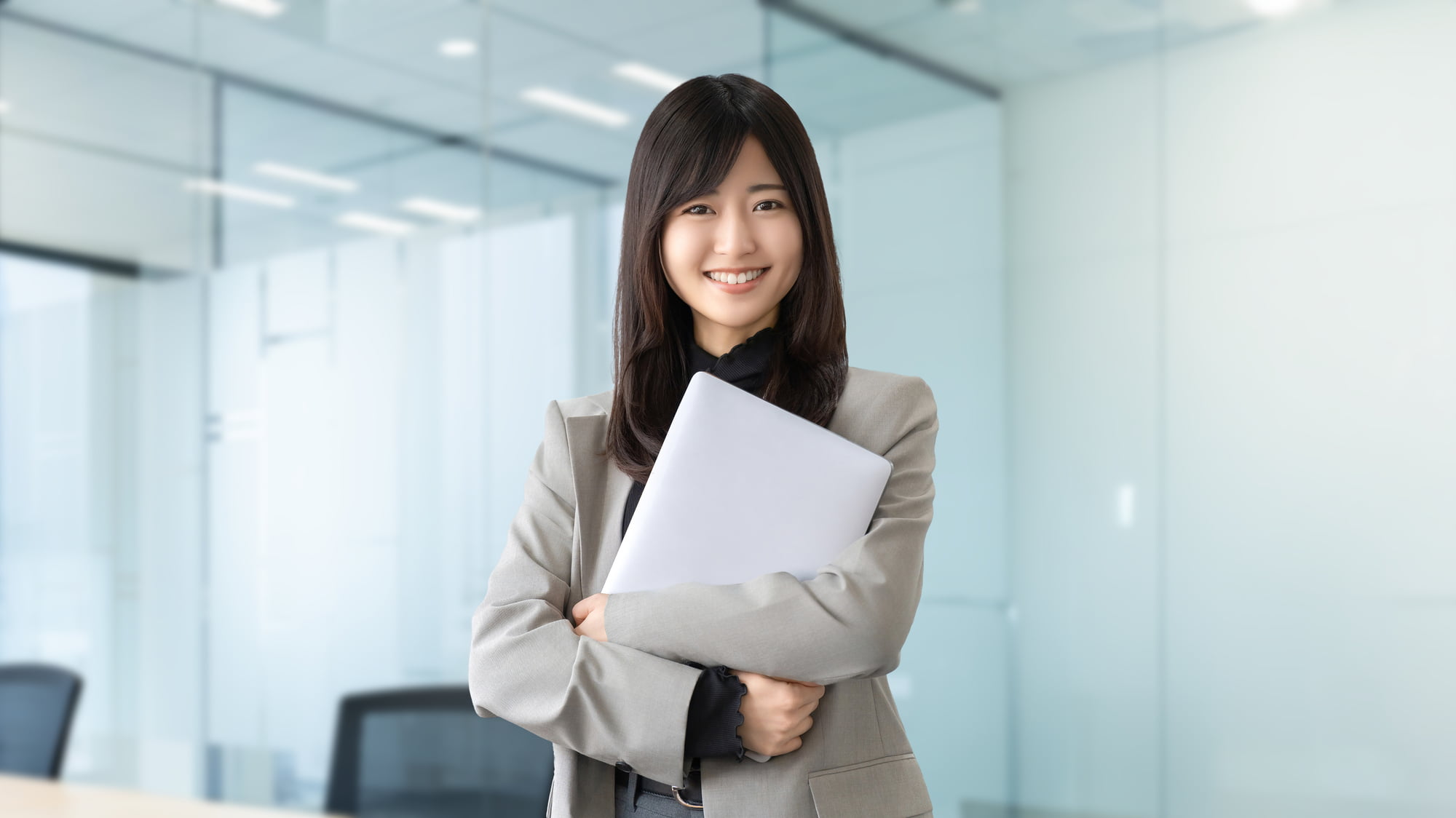 ノートパソコンを持った笑顔の若い女性