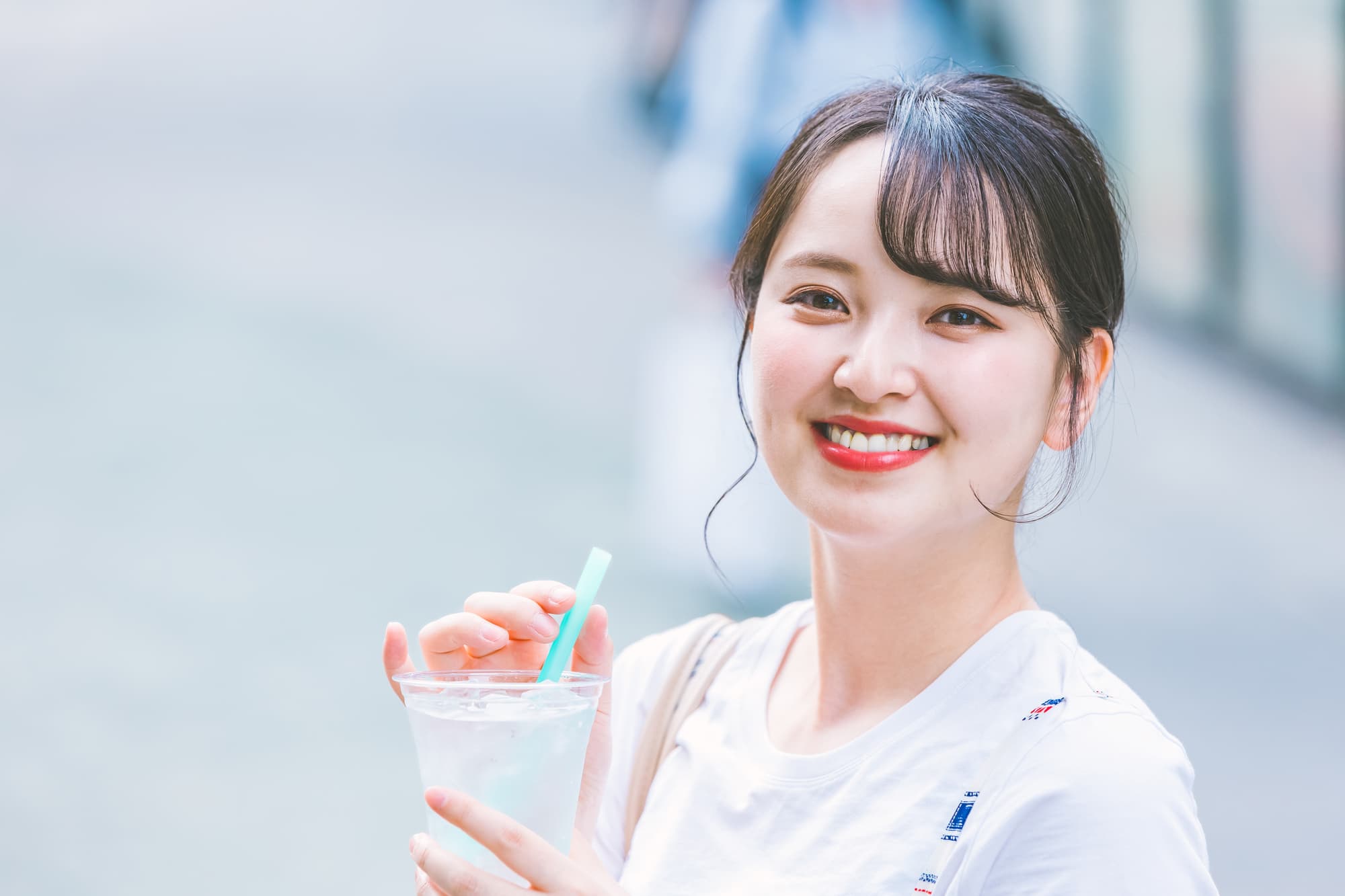 冷たい飲み物を飲む笑顔の女性