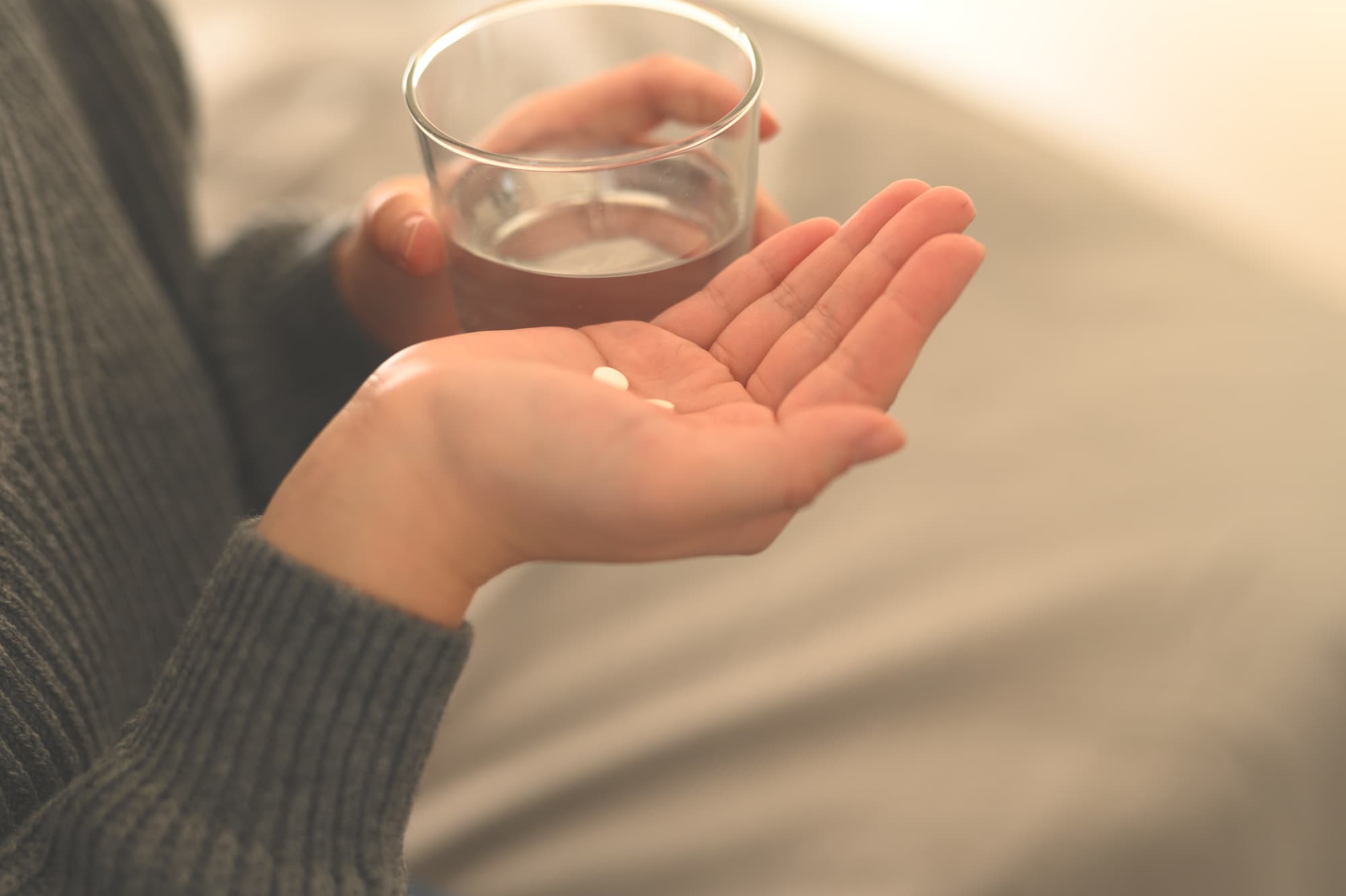 痛み止めを飲もうとしている女性の手元